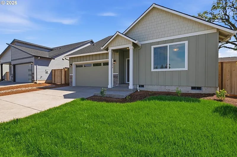 A new single-story home with a covered entry and a lush green lawn